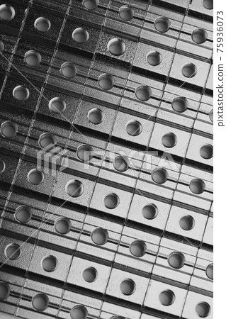 slide screw nuts in a row, abstract industrial background slide screw nuts in a row, abstract industrial background 75936073