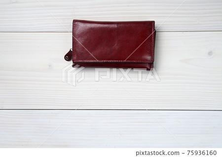 Leather purse on a white wooden background 75936160