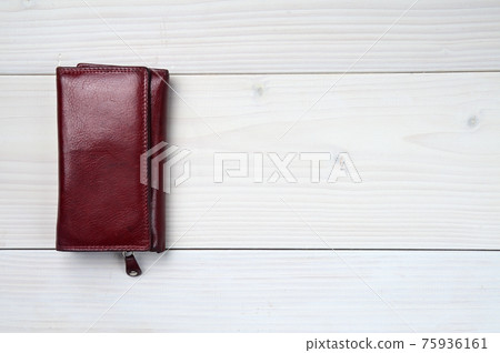 Leather purse on a white wooden background 75936161