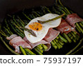 Bacon wrapped asparagus with a fried egg 75937197