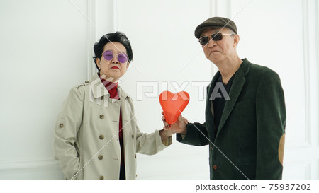 Asian elder senior couple hold love red balloon in fashion winter clothes happy marriage life Asian elder senior couple hold love red balloon in fashion winter clothes happy marriage life 75937202