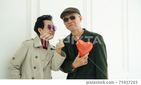 Asian elder senior couple hold love red balloon in fashion winter clothes happy marriage life Asian elder senior couple hold love red balloon in fashion winter clothes happy marriage life 75937203
