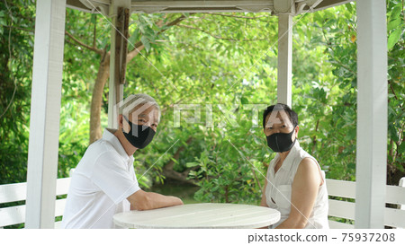 Asian elder senior couple wear mask quarantine eascape in green natural park background happy in nature Asian elder senior couple wear mask quarantine eascape in green natural park background happy in nature 75937208