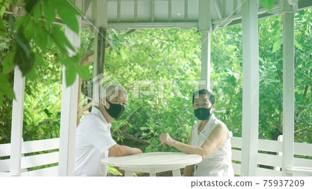 Asian elder senior couple wear mask quarantine eascape in green natural park background happy in nature 75937209