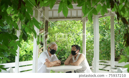 Asian elder senior couple wear mask quarantine eascape in green natural park background happy in nature Asian elder senior couple wear mask quarantine eascape in green natural park background happy in nature 75937210