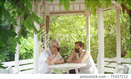 Asian elder senior couple wear mask quarantine eascape in green natural park background happy in nature 75937212