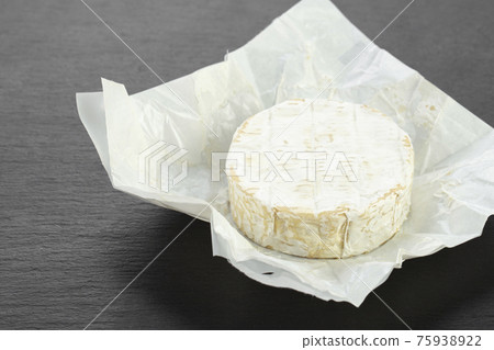 Camembert cheese circle on a black background. 75938922