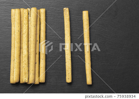 Homemade Italian Grissini Breadsticks on a black background. Homemade Italian Grissini Breadsticks on a black background. 75938934