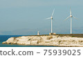 Wind turbines with blades in field vith blue sky. Alternative electric energy production. 75939025