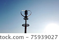 Vertical axis wind turbine utilize renewable wind energy while spinning against blue sky. 75939027
