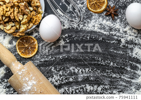 Bakery products. Cooking food ingredients: flour, eggs, nut and star anise, orange on dark table kitchen background for cake. Still life captured from above, top view, flat lay. Bakery products. Cooking food ingredients: flour, eggs, nut and star anise, orange on dark table kitchen background for cake. Still life captured from above, top view, flat lay. 75941111