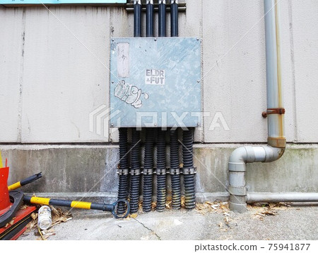 A pull box in a back alley building in the city 75941877