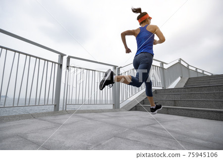 Healthy lifestyle fitness sports woman runner running on seaside trail Healthy lifestyle fitness sports woman runner running on seaside trail 75945106