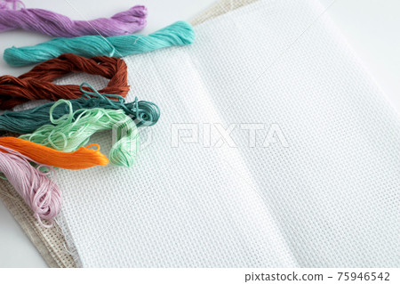 Sewing threads of different colors on the canvas for embroidery. Colorful mouline threads of floss Sewing threads of different colors on the canvas for embroidery. Colorful mouline threads of floss 75946542