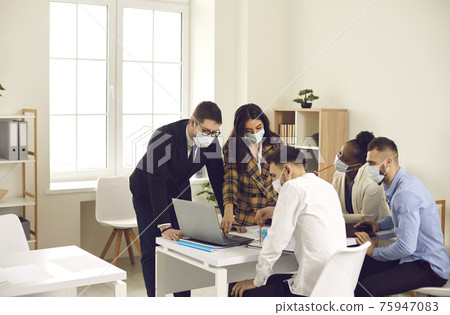 Business people team wearing face mask while working together in office Business people team wearing face mask while working together in office 75947083