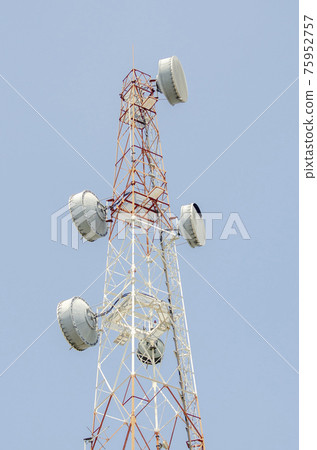 Telecommunication tower on clean blue sky background. Tower poles and wireless telephone antennas. Telecommunication tower on clean blue sky background. Tower poles and wireless telephone antennas. 75952757