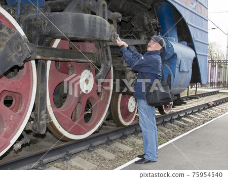 The machinist repairs a steam locomotive The machinist repairs a steam locomotive 75954540