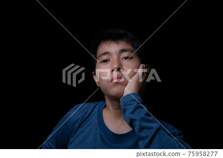 Asian man getting bore something on black background. 75958277