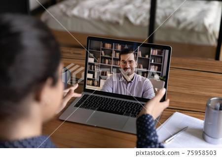 Rear view Indian woman making video call to colleague Rear view Indian woman making video call to colleague 75958503