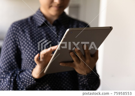 Close up Indian woman holding using tablet, browsing apps Close up Indian woman holding using tablet, browsing apps 75958553