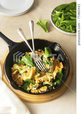 Spinach and cheese omelet, scrumblet eggs, healthy breakfast food in frying pan Spinach and cheese omelet, scrumblet eggs, healthy breakfast food in frying pan 75960481