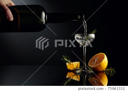 Gin with lemon and rosemary on a black reflective background. 75961552