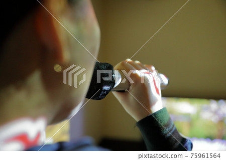 A woman who enjoys singing karaoke enthusiastically 75961564