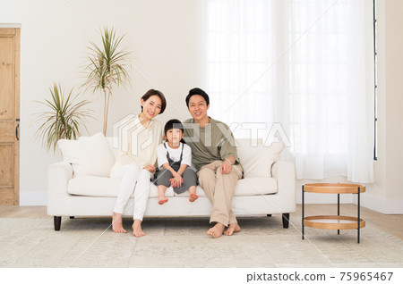 一家三口微笑的父母坐在沙發上 一家三口微笑的父母坐在沙發上 75965467