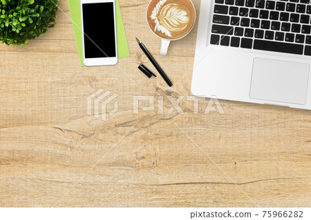 Wood office desk table with laptop computer, latte coffee, smartphone and supplies. Top view with copy space, flat lay. Wood office desk table with laptop computer, latte coffee, smartphone and supplies. Top view with copy space, flat lay. 75966282