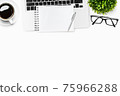 Modern white office desk table with laptop, blank notebook, and supplies. Top view with copy space, flat lay. 75966288