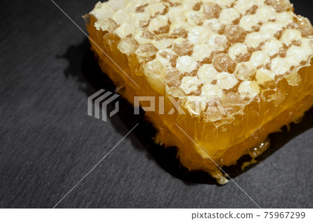 fresh honeycomb covered with wax on stone dark background fresh honeycomb covered with wax on stone dark background 75967299