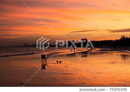 Chair and flipflop on beach at sunset 75970300