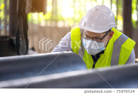 Engineers examine new coated pipe in factory, Ventory Check 75970534
