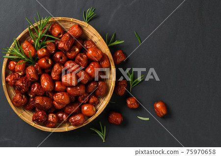 Dried Jujube, Chinese dried red date fruit with rosemary leaf in bamboo basket on black background, Dried Jujube, Chinese dried red date fruit with rosemary leaf in bamboo basket on black background, 75970658