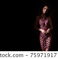 Portrait of a young, brunette, classy woman posing in shade 75971917
