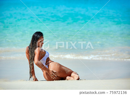 Sexy girl in white swimsuit enjoying at the tropical beach Sexy girl in white swimsuit enjoying at the tropical beach 75972136