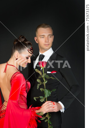 Sensual woman and man with rose flower. Woman in red 75973375