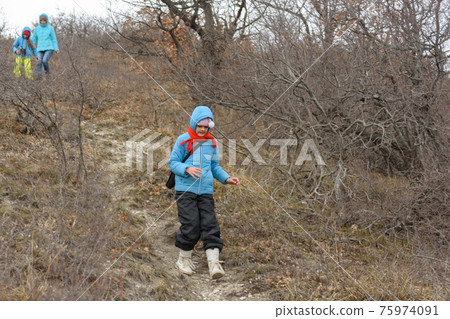 A girl runs down the path from the mountain, in the background a girl with another girl gently descend from the mountain A girl runs down the path from the mountain, in the background a girl with another girl gently descend from the mountain 75974091
