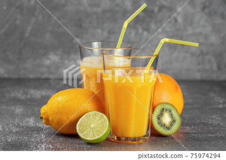 Freshly squeezed orange juice and banana and orange smoothies in tall glasses 75974294