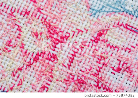 Close-up of the wrong side of a cross-stitched canvas with a pattern Close-up of the wrong side of a cross-stitched canvas with a pattern 75974382