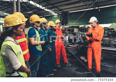 Skillful worker attending brief meeting in the factory . Skillful worker attending brief meeting in the factory . 75974384