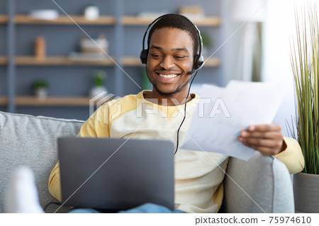 Successful black man having video call with colleagues from home 75974610