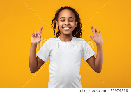 Hopeful african american girl crossing her fingers 75974818