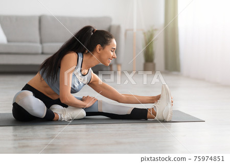 Joyful sporty lady having workout at home 75974851