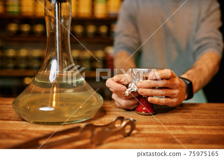 Male hookah maker, smoking preparation in bar 75975165