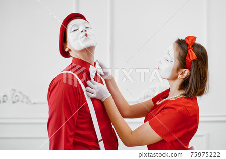 Mime artists in red costumes look at each other 75975222
