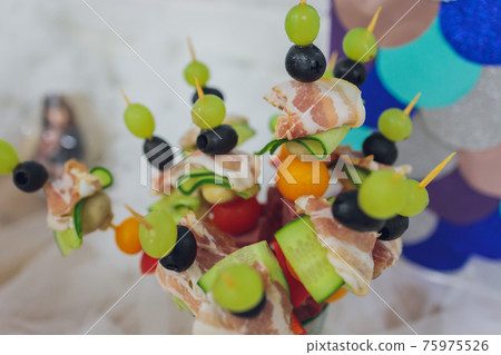 Beautifully decorated catering banquet table with different food snacks and appetizers with sandwich, caviar, fresh fruits on corporate christmas birthday party event or wedding celebration. 75975526