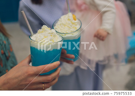 Woman with tasty milk shake on blue background, closeup. Woman with tasty milk shake on blue background, closeup. 75975533