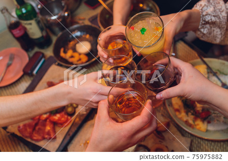 Clinking glasses with alcohol and toasting, party. 75975882