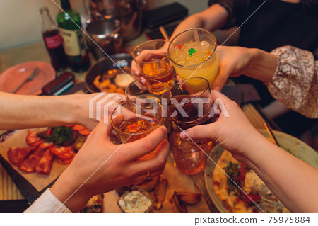 Clinking glasses with alcohol and toasting, party. 75975884